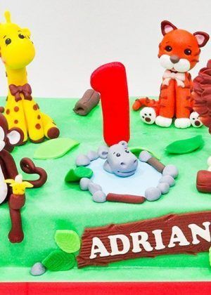 Tarta animales de la selva 1 año con jirafa, mono, tigre, león, hipopótamo, número 1 y nombre ADRIAN en Auxai Tartas