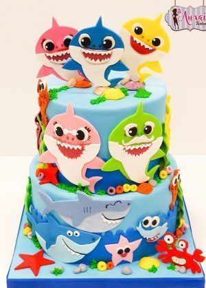 Tarta Baby Shark 2 pisos con tiburones bebé rosa, azul y amarillo, estrellas de mar y cangrejos en Auxai Tartas