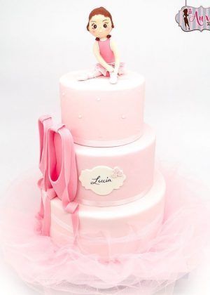 Tarta bailarina zapatillas con figura de bailarina sentada ajustándose las zapatillas, nombre LUCIA y base de tul en Auxai Tartas