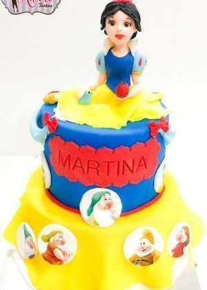 Tarta Disney Princesa Blancanieves con figura de Blancanieves, siete enanitos y nombre Martina en lazo rojo