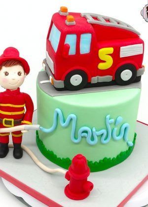 Tarta Bombero infantil con figura de bombero, camión de bomberos rojo y nombre Martín