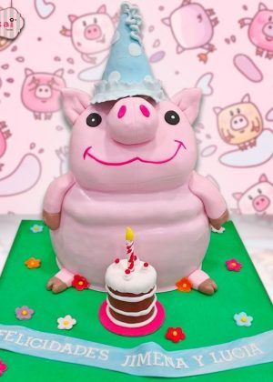 Tarta 3D cerdito de peluche rosa con gorro de fiesta azul y mensaje Felicidades Jimena y Lucía