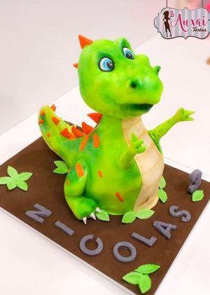 Tarta tallada dinosaurio 3D con figura grande de dinosaurio bebé verde y nombre Nicolas en la base