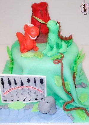 Tarta dinosaurios de dibujos animados con dinosaurio rojo y verde, volcán y mensaje de felicitación