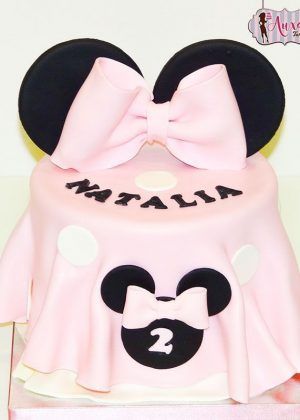 Tarta Disney Minnie Mouse orejas y falda rosa con orejas negras, lazo rosa y falda plisada con lunares