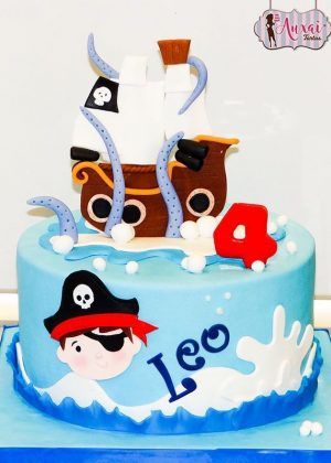 Tarta barco pirata 2D azul con barco pirata, velas blancas, bandera con calavera, pirata con parche y nombre Leo en letras azules