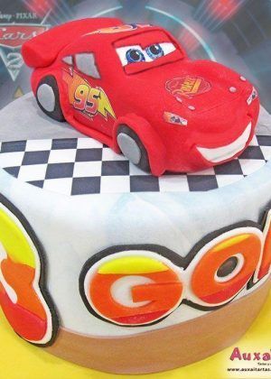 Tarta Disney Rayo McQueen bandera a cuadros con figura 3D del coche rojo número 95 sobre superficie con bandera a cuadros y nombre Gon