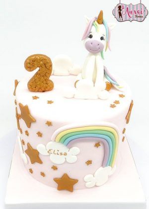 Tarta unicornio dorado con figura 3D de unicornio blanco sentado, cuerno dorado, número 2 glitter dorado y nombre ELISA en nube con arcoíris y estrellas doradas