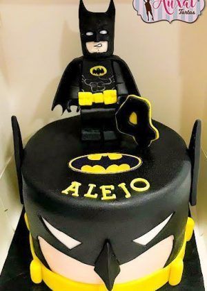 Tarta personalizada Batman Lego con base negra y emblema amarillo del murciélago. Decoración profesional de tarta de superhéroes