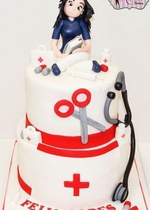 Tarta Enfermera personalizada con fondant blanco, cruz médica roja, estetoscopio y decoración en rojo para celebración de profesionales sanitarios