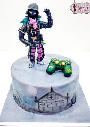 Tarta personalizada en forma de personaje The Raven de Fortnite con fondant premium en tonos púrpura, negro, azul oscuro. Base decorada con logo FORTNITE BATTLE ROYALE.