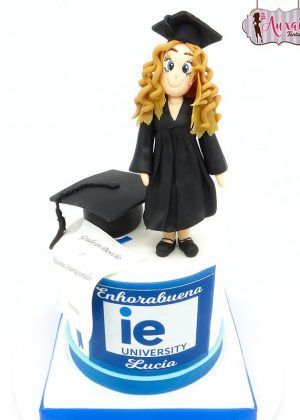 Tarta de graduación chica con fondant azul brillante y figura de graduado en la cima, diseño profesional para celebraciones académicas