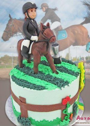 Tarta temática artesanal Caballos Niña Amazona con dos pisos: fondant rojo ladrillo en la base y verde menta en el segundo nivel, decorada con un caballo verde oscuro detallado, figura de una niña amazona, árbol temático y flores amarillas. Creación personalizada de pastelería gourmet para celebraciones infantiles.