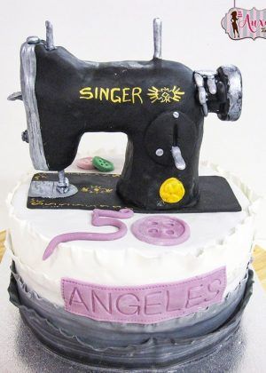 Tarta máquina de coser Singer con detalles plateados, logo dorado y nombre Ángeles 50 años – ideal para cumpleaños de costura
