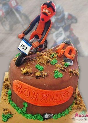 Tarta motocross con figura 3D de piloto en salto, número 40 y placa BOXXXNIO en Auxaitartas