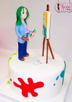 Tarta pintora con figura 3D de artista frente a caballete y salpicaduras coloridas en Auxaitartas