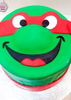 Tarta tortugas ninja en 2D con cara de Rafael, máscara roja y sonrisa en Auxaitartas