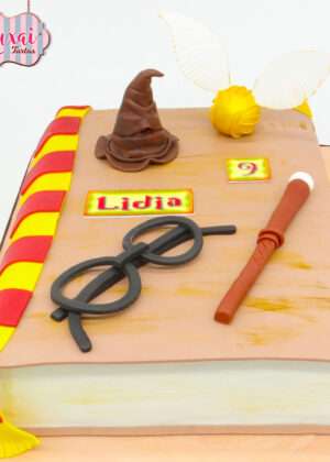 Tarta libro Harry Potter con fondant blanco premium, diseño de libro abierto, gafas redondas, cicatriz relámpago y texto LIBRO en amarillo dorado, detalles cinematográficos excepcionales