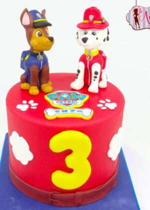 Tarta Patrulla Canina 2 perros con figuras de Chase y Marshall sobre superficie roja y número 3 amarillo