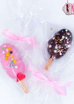 Cake bars infantiles con cobertura rosa y chocolate decoradas con sprinkles y estrellas, envueltas en celofán con lazo rosa