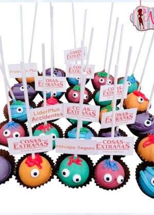 Cakepops halloween monstruos coloridos con ojos grandes, expresiones divertidas y palos blancos, dispuestos en un bouquet festivo para Halloween