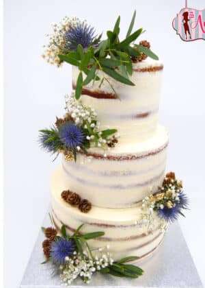 Tarta boda semi naked invierno de tres pisos con decoración de flores azules, eucalipto, gypsophila y piñas naturales