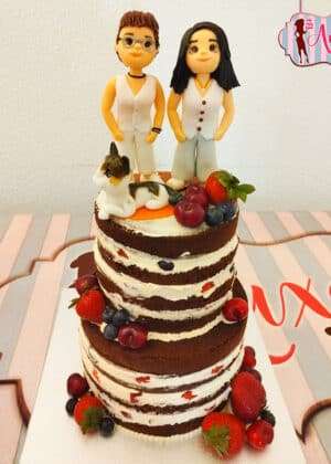 Tarta boda naked chicas de dos pisos con figuras personalizadas de dos novias, gato y decoración de frutas frescas como fresas y arándanos