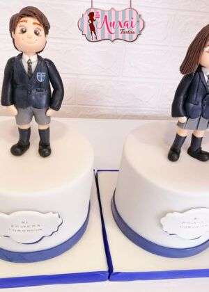Tarta comunión mellizos con figuras 3D de niño y niña en uniforme en Auxaitartas