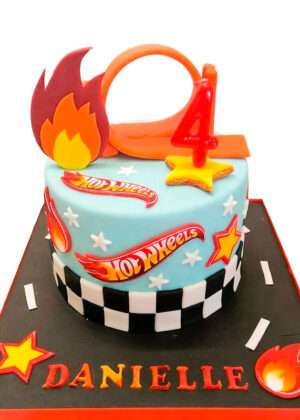 Tarta Hot Wheels en Madrid de diseño infantil con pista naranja en bucle y detalles de llamas en pasta de azúcar