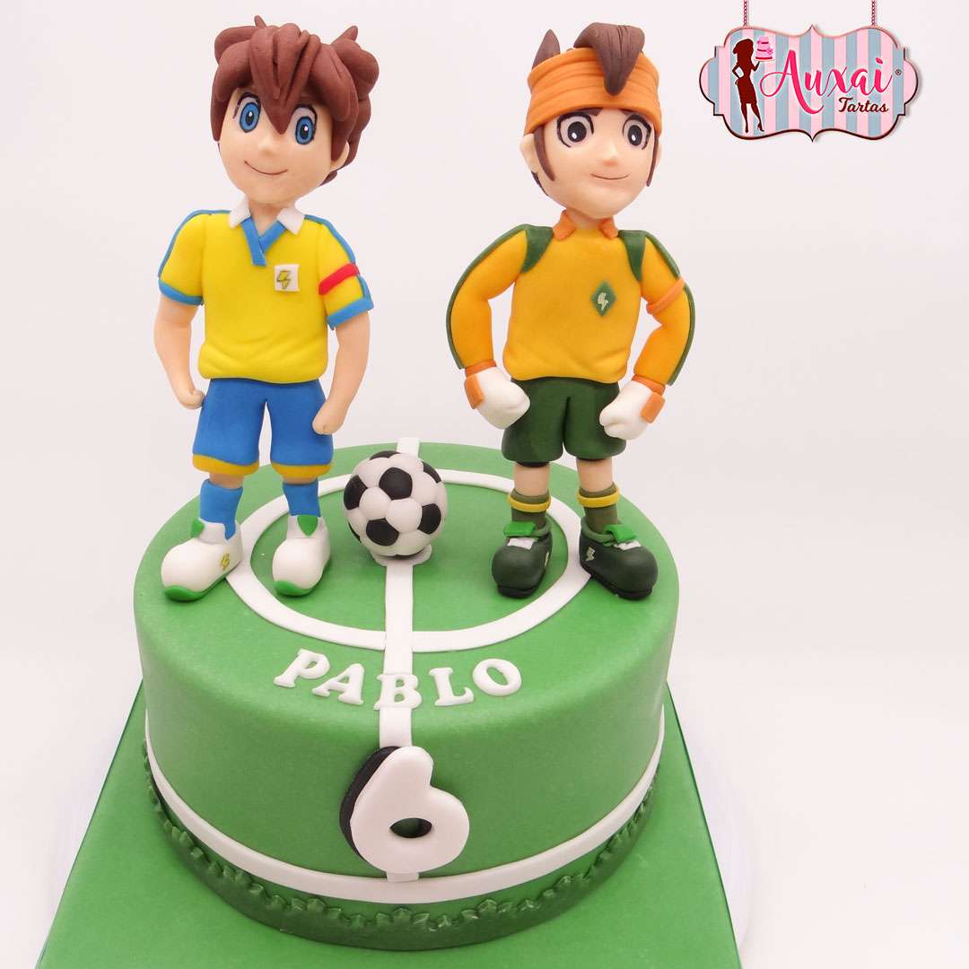 Tarta futbol inazuma eleven madrid con personajes modelados en fondant sobre campo de fútbol verde para cumpleaños infantil