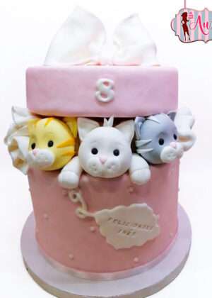Tarta de cumpleaños infantil en Madrid con diseño de caja de regalo rosa y tres gatitos de fondant asomando