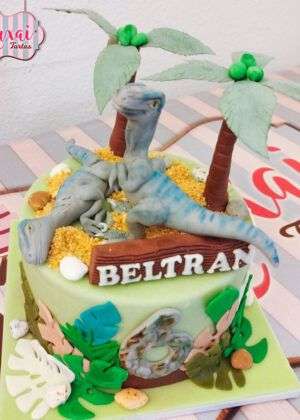Tarta dinosaurios velociraptor en Madrid con figuras de fondant y palmeras de azúcar