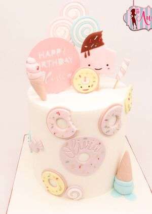 Tarta infantil de donuts y helados en Madrid decorada en tonos pastel rosa y azul con figuras de fondant para cumpleaños
