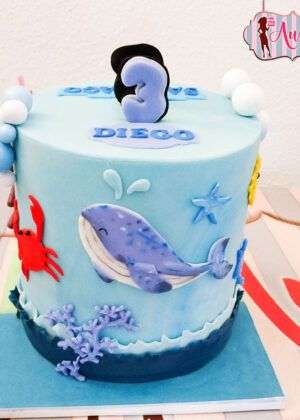 Tarta infantil de ballena en Madrid decorada en tonos azules con detalles marinos de pasta de azúcar para cumpleaños de Diego