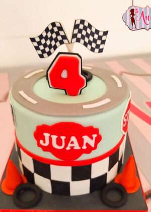 Tarta infantil de carreras gran premio personalizada con nombre Juan, bandera de cuadros y detalles de fondant en Madrid