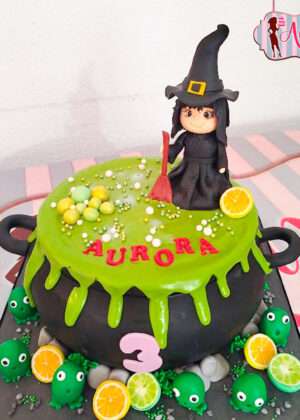 Tarta halloween brujita en caldero modelada a mano en Madrid con detalles de poción verde y monstruos de azúcar.