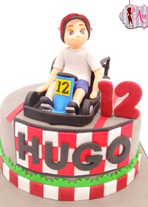 Tarta infantil karts madrid con figura de fondant de piloto en coche de carreras y nombre Hugo
