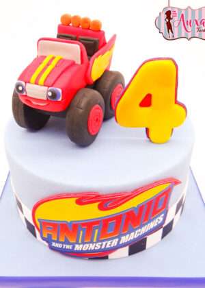 Tarta infantil monster machine madrid cubierta de fondant azul con coche modelado en color rojo en la parte superior