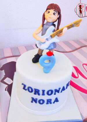 Tarta niña guitarra electrica modelada en azúcar con detalles de fondant azul y nombre de Nora para cumpleaños en Madrid