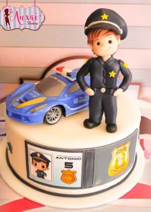 Tarta infantil de policía personalizada en Madrid con coche deportivo azul y figura de fondant modelada a mano