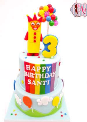 Tarta personalizada numberblocks madrid de dos pisos en tonos pastel con el personaje número tres modelado en fondant para un cumpleaños infantil