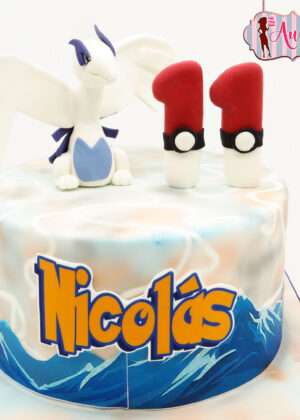 Tarta pokemon lugia madrid decorada con olas azules y figura de fondant del pokémon legendario.