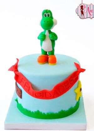 Tarta fondant yoshi madrid con modelado tridimensional del personaje sobre cobertura azul pastel y detalles decorativos de Super Mario.