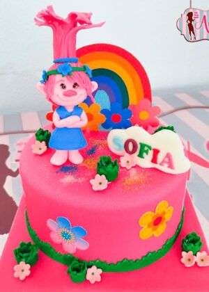 Tarta trolls poppy arcoiris de diseño infantil con figura de Poppy modelada a mano y arcoíris de fondant en Madrid.